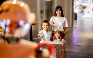 A mom and two kids interacting with an exhibit at Ripley's Believe It or Not in Newport.