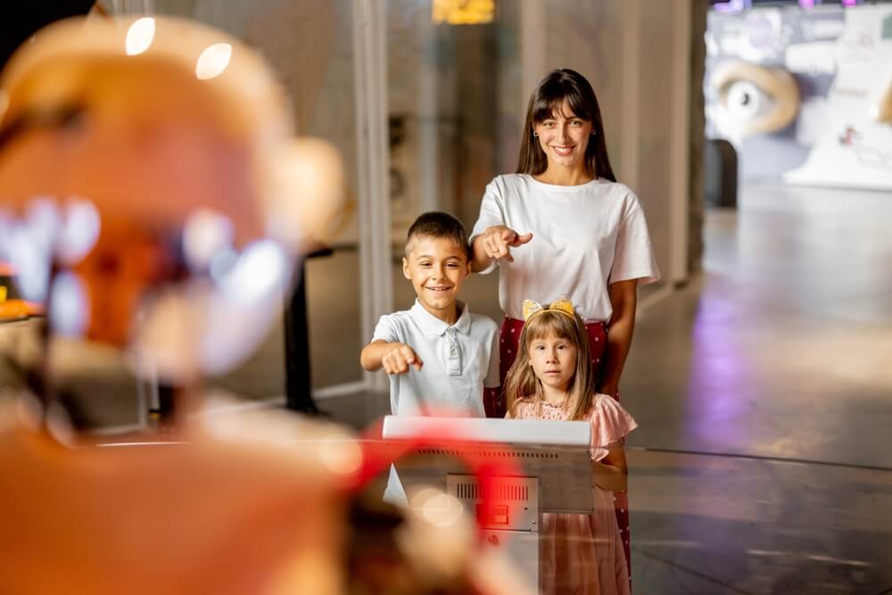 A mom and two kids interacting with an exhibit at Ripley's Believe It or Not in Newport.